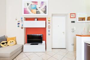uma sala de estar com um sofá e uma televisão em Giardino Vignoli Functional Apartment em Bolonha