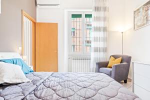 um quarto com uma cama, uma cadeira e uma janela em Giardino Vignoli Functional Apartment em Bolonha