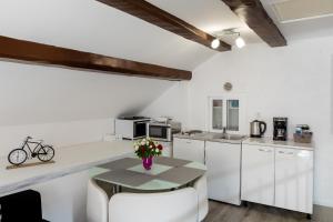 eine Küche mit weißen Arbeitsflächen und einem Tisch mit einer Blumenvase in der Unterkunft Old Town Charming Nest in Dubrovnik