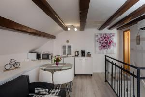 a living room with a table and a kitchen at Old Town Charming Nest in Dubrovnik