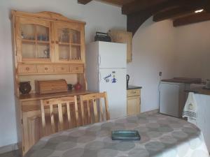 eine Küche mit weißem Kühlschrank und Holzschränken in der Unterkunft Erdő szélén Házikó Gyenesdiás in Gyenesdiás + 4 Fotos