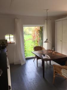 a dining room with a table and a large window at Appartement im alten Pferdestall in Salzhausen