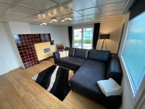 a living room with a black leather couch at Haus Raid in Krumbach