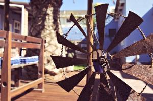 a black windmill on a wooden deck with a bench at Haus Sandrose in Lüderitz