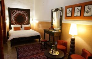 a hotel room with a bed and a mirror at Riad le Clos des Arts in Marrakech