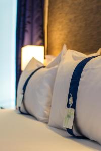 a bed with white pillows with a price tag on it at Holiday Inn Express Lisboa - Av. Liberdade, an IHG Hotel in Lisbon