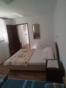 a bedroom with a large bed with a mirror and a mirror at Family apartman Ana - Star in Golubac