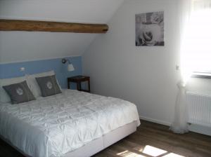 1 dormitorio con cama blanca y ventana en Bed op de Reth, en Baarle-Nassau