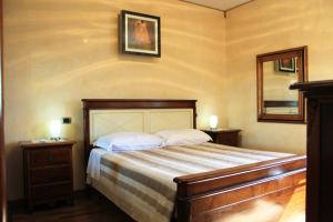 a bedroom with a bed with two night stands and a mirror at Il Vivaio in Tarquinia