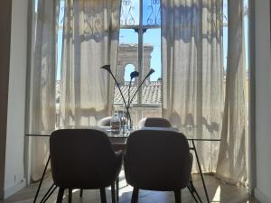 a dining room table with chairs in front of a window at Mirador de Zocodover in Toledo