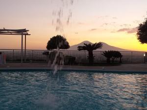 a fountain in a pool with a sunset in the background at Il Saretto in Sarno