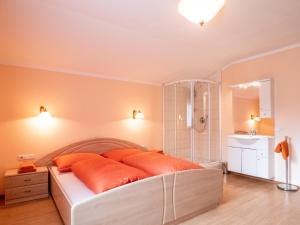 um quarto com uma cama com almofadas laranja e um chuveiro em Village Apartments em Achenkirch