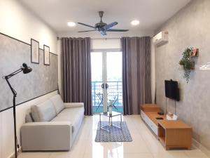 a living room with a couch and a tv at Residensi Flora in Seri Kembangan