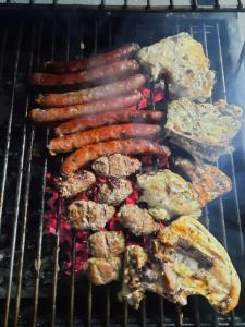 - un plat de viande et de saucisses sur un grill dans l'établissement SUPERBE VILLA AVEC PISCINE PLAGES DES NATIONS, à Rabat