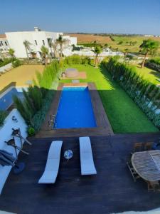 een zwembad in een tuin met een gazon bij SUPERBE VILLA AVEC PISCINE PLAGES DES NATIONS in Rabat