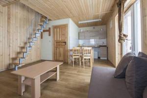 a living room with a table and a spiral staircase at Domek u Małysza Istebna in Istebna