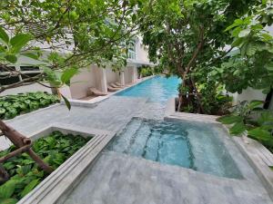 a swimming pool in the middle of a building with trees at CHERN Bangkok in Bangkok