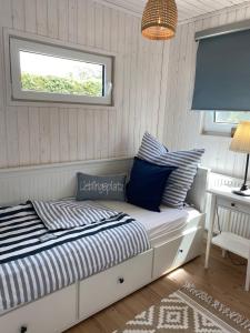 Bett in einem Zimmer mit einem Fenster und einem Tisch in der Unterkunft Ferienhaus Grosses Meer mit Boot in Südbrookmerland