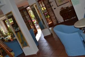 a living room with blue chairs and a table at Hotel Danila in Portoferraio