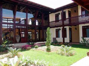 a large building with a garden in front of it at OYO Hotel La Dolce Vita, Rio das Ostras in Rio das Ostras