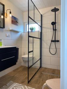 SüdbrookmerlandにあるFerienhaus Grosses Meer mit Bootのシャワーとトイレ付きのバスルーム