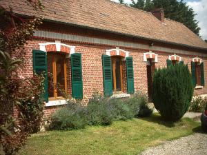 a red brick house with green shutters on it at Fermette 3ch - 6p au pays du coquelicot by La Source d'OrFée in Courcelette