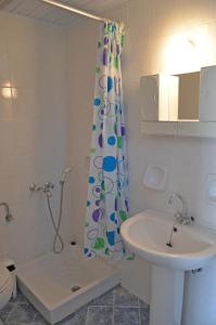 a bathroom with a shower curtain and a sink at NIKOS APARTMENTS in Laganas