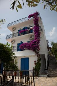 un edificio con fiori viola sul lato di Villa Nina a Città di Skiathos