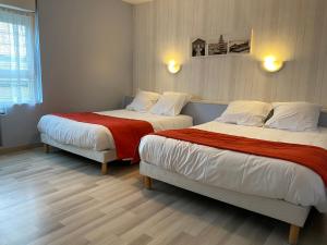 a bed room with a white bedspread and white pillows at Hotel de Bretagne in Fougères