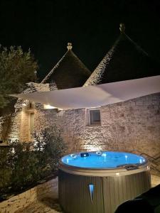 uma banheira de hidromassagem em frente a uma casa à noite em Villa Sardedda em Locorotondo