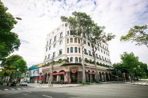 Kim Minh Apartment & Hotel في فنغ تاو: مبنى ابيض على زاوية شارع