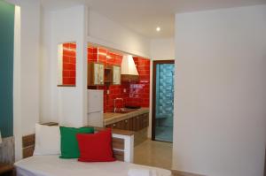 a room with a bed with red and green pillows at Giorgos Apartments Square in Nea Vrasna +79 photos