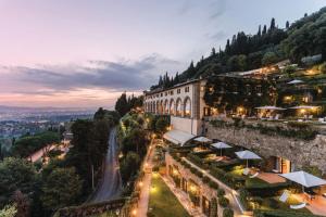 a building on the side of a mountain at night at Villa San Michele, A Belmond Hotel, Florence in Fiesole