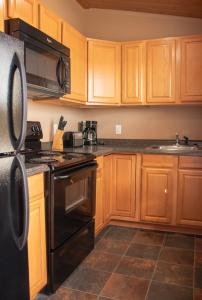 a kitchen with wooden cabinets and a black stove top oven at Tumbleweed Lodge - No Smoking, No Pets in Monahans