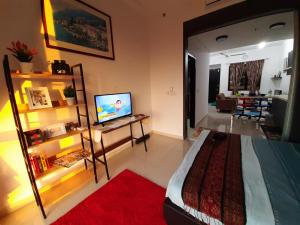 a bedroom with a bed and a desk with a television at MyCozySOHO with Excellent Swimming Pool View in Cyberjaya