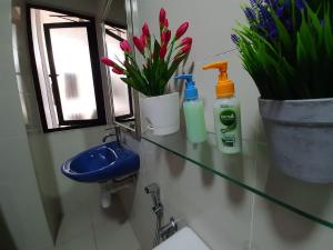 a bathroom with a sink and a toilet and flowers at MyCozySOHO with Excellent Swimming Pool View in Cyberjaya