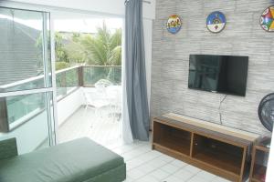 a living room with a flat screen tv on a wall at Ancorar Flat Resort 5202 in Ipojuca