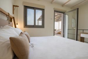 a bedroom with a large white bed with a window at CIEL BOUTIQUE VILLAS in Afiartis