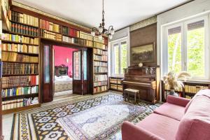 ein Wohnzimmer mit Bücherregalen und einem Klavier in der Unterkunft Trastevere Decò Apartment in Rom