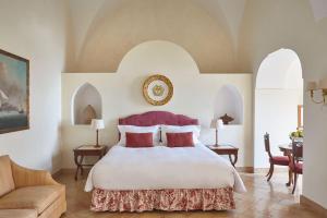 a bedroom with a large bed with red pillows at Caruso, A Belmond Hotel, Amalfi Coast in Ravello