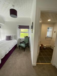 - une chambre avec un lit et une chaise verte dans l'établissement Millburn, à Dunvegan