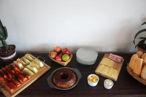a table topped with different types of food and fruits at Massambaba Hostel in Arraial do Cabo