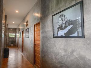 a hallway with a large painting on the wall at Bosston Hotel in Phetchaburi