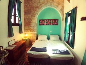 um quarto com uma cama e uma parede verde em Turquoise em Nablus