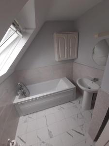 a white bathroom with a tub and a sink at Mount Alohert House in Killarney +21 photos