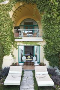 a patio with two white couches and a balcony at Caruso, A Belmond Hotel, Amalfi Coast in Ravello