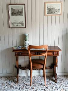 een houten bureau met een stoel in een kamer bij Via Funicolare in Brunate