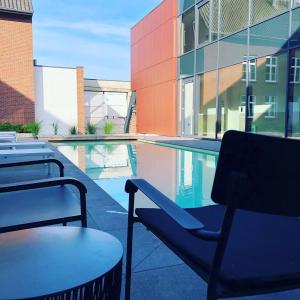 einen Pool mit einem Stuhl neben einem Gebäude in der Unterkunft Hof van Stayen in Sint-Truiden