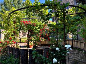 a garden with a pergola with red and white flowers at Mina Hotel in Goris