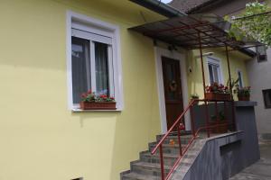 a yellow house with stairs and flower boxes on it at La Bella in Sibiu